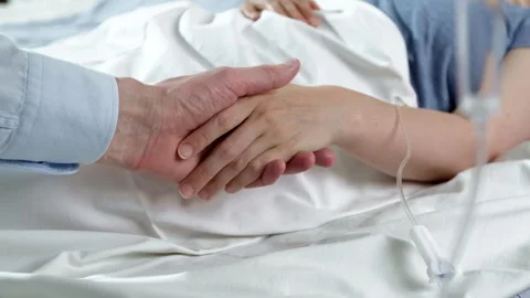The support hand of a patient lying under a drip and a doctor or relative.  Stock Footage 247192214