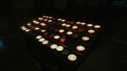 Support with lit candles inside a dark church. Stock Footage 107425034