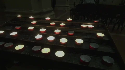 Support with lit candles inside a dark church. Stock Footage 107425437