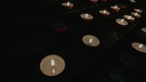 Support with lit candles inside a dark church. Stock Footage 107425508