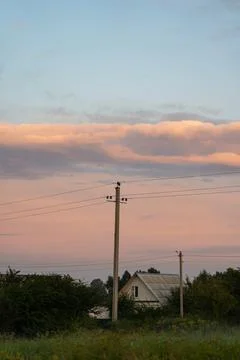 The support of power lines against the background of an orange sunset sky Stock Photos