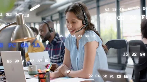 Support rep taking call, typing on laptop, checking charts with data overlay Stock Footage 333539800