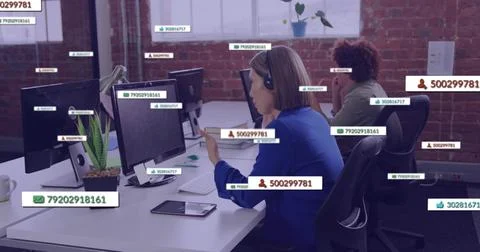 Support rep typing, speaking on headset with incoming IDs appearing on screens Stock Photos