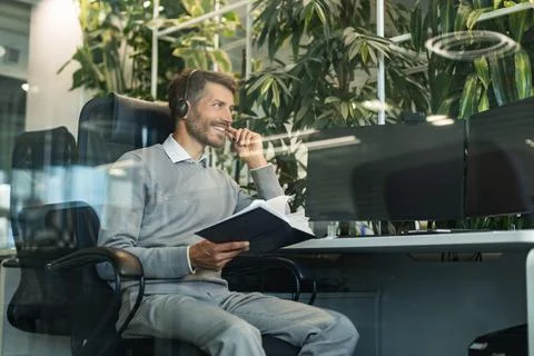 Support service operator talking to customer sitting at desk wearing headset  Stock Photos