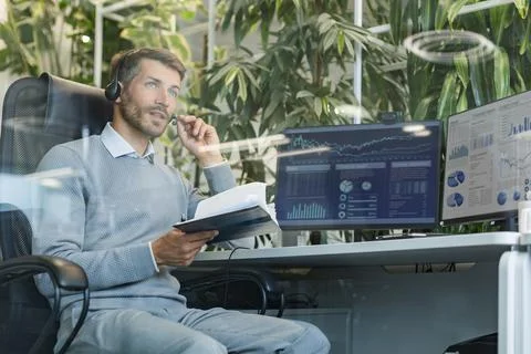 Support service operator talking to customer sitting at desk wearing headse.. Stock Photos
