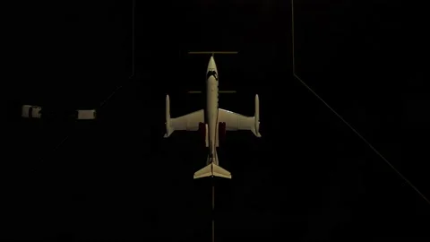 Support vehicle pulling away from parked private jet at night, top down Stock Footage 218577398