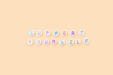 Support yourself. Quote made of white round beads with colorful letters. Stock Photos