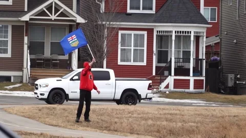 A supporter of the Alberta independence movement waves the provincial flag Stock Footage 329486846
