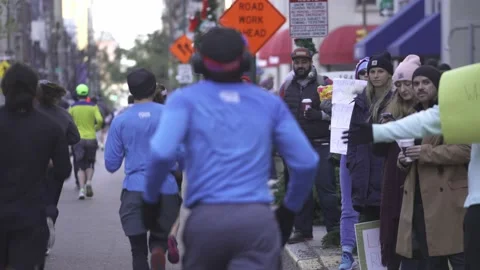 Supporters With Posters Tapping Hands Of Runners On The Street During Stock Footage 227136477