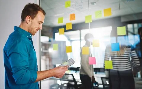 Supporting a problem solving session with smart technology. a young man using a 写真素材