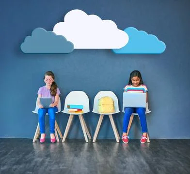 Supporting schoolwork with wireless technology. Studio shot of kids sitting on Stock Photos