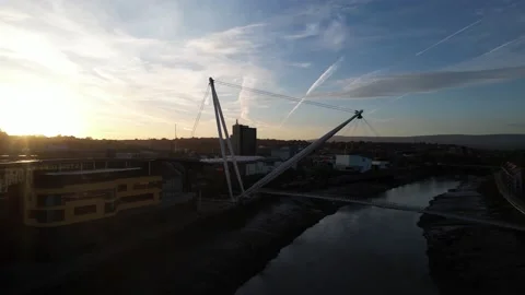 Supporting structure of footbridge over river in town, sunset sky Stock Footage 166542284