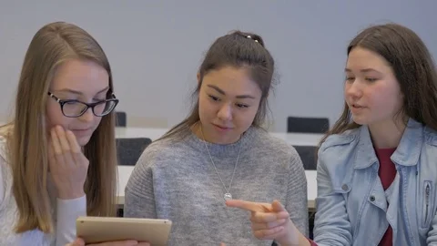 Supportive girl explaining to her classmates in the classroom Stock Footage 74625265