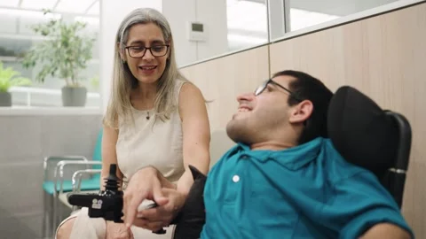 Supportive mother talking with son with disability in hospital Stock Footage 339324037