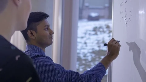 Supportive student explaining to his classmate in the classroom 動画素材 74623247