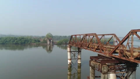 Supports and truss old, rusty, dilapidated bridge over the river. Aerial view. Stock Footage 85481272