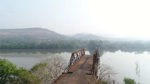 Supports and truss old, rusty, dilapidated bridge over the river. Aerial view. Stock-Footage 85481570
