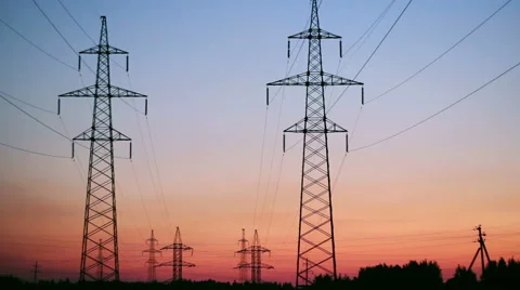 Supports high-voltage lines stretching over the horizon at sunrise Stock Footage 65094662