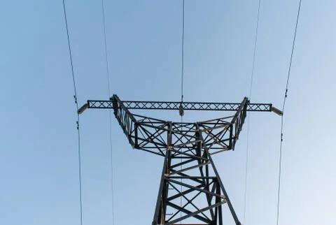 Supports high-voltage power lines against the blue sky. Stock Photos