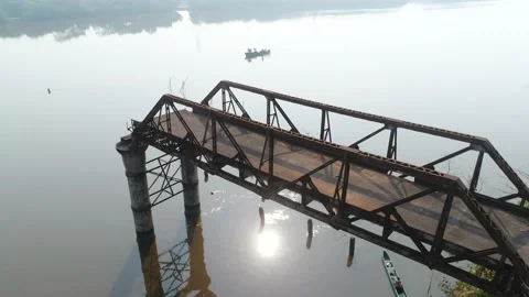 Supports old, rusty, dilapidated bridge over the river. Aerial view. Stock Footage 85485477