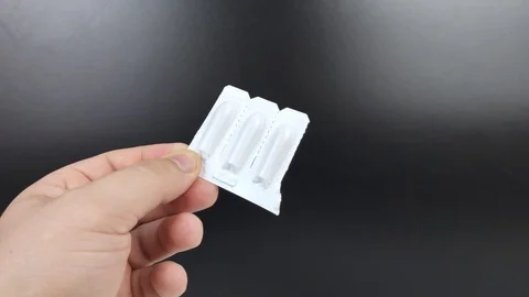 Suppositories in white packaging in the hands of a man. Macro video of rectal or Stock Footage 125894054