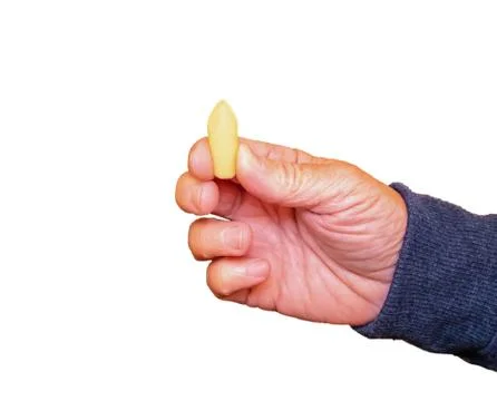 Suppository for constipation in the hand of an elderly person against the whi Stock Photos