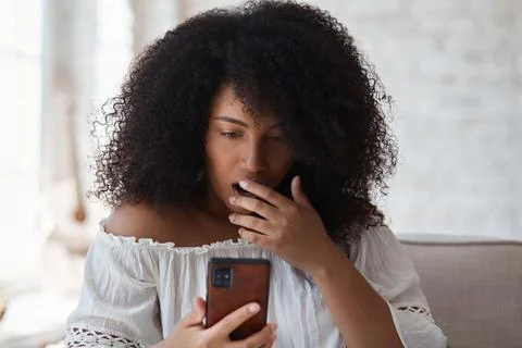 Suprized shocked woman looking at smartphone screen watching strange weird funny Stock Photos