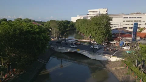 Surabaya, East Java - June 24th, 2026: Vehicles crossing a small bridge Aerial Vídeos de archivo 338037825