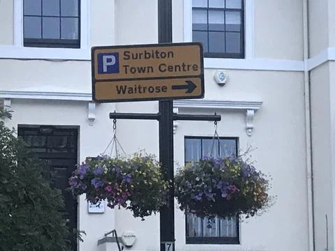 Surbiton and Waitrose Upper Middleclass / Posh street sign with hanging baskets Foto stock
