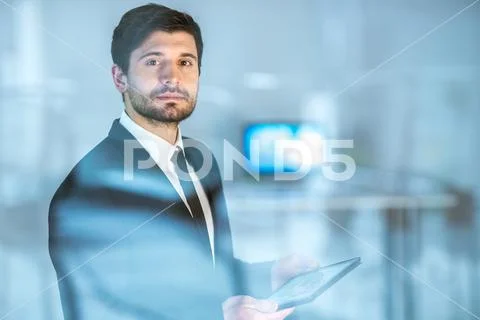 The sure businessman stand with a tablet near the window Stock Photos