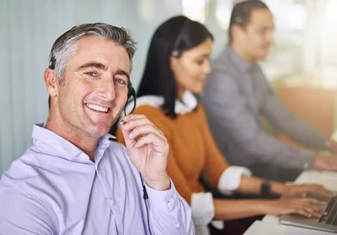 Sure, one second. Cropped portrait of a man working at his desk. Stock Photos