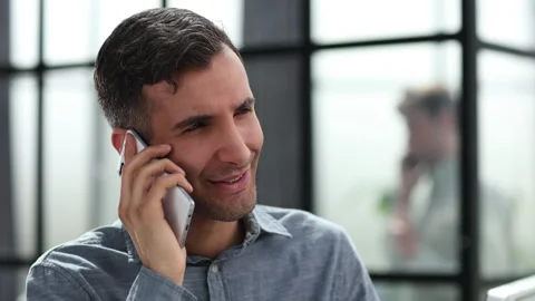 Sure, we can do that for you. A young businessman talking on the phone while Vídeos de archivo 246712344
