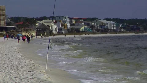 Surf breaking foreground with condominiums and people in distant background Stock Footage 70066391