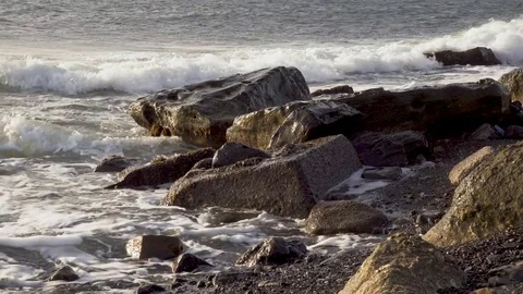 Surf breaks down about big boulders Stock Footage 82448907
