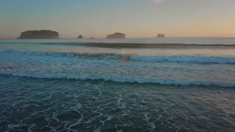 Surf breaks on a tropical beach with islands in the background Stock Footage 148080331