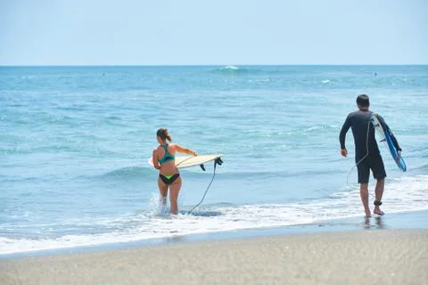 Surf couple on a beach Stock Photos