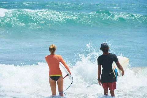 Surf couple on a beach Stock Photos