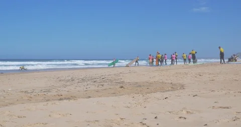 Surf School on the Beach about to go into the Tide for their first Surf Lesson Video stock 120293689