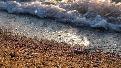 Surf of a sea wave close-up. Coarse sand with small pebbles on the shore Stock Footage 127044649