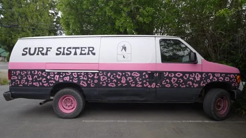 Surf Sister surf school van with pink leopard print graphics parked beside Stock Footage 337196676