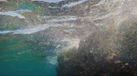 Surf under water, waves breaking on the rocks Stock Footage