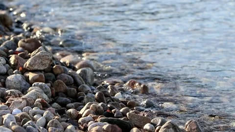 The surf washes the pebble beach at sunset. Stock Footage 143918467