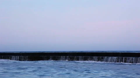 Surf Wave on the Breakwater at Sunset. Slow Motion 動画素材 106464528