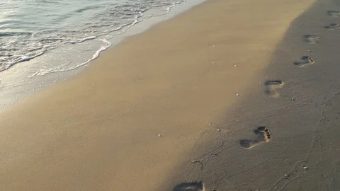 Surf waves human footprints in the sand Stock Footage 116423580