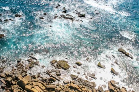 Surf, waves rush into the rocks, top view Stock Photos