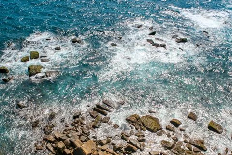 Surf, waves rush into the rocks, top view Stock Photos