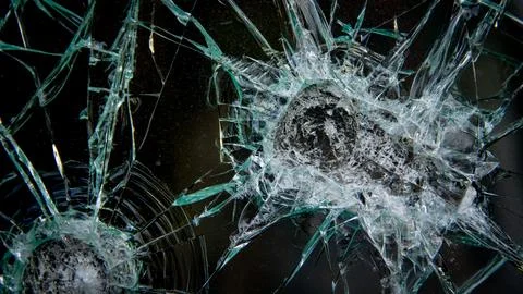 Surface of broken glass with multiple impact points and diverging cracks. Stock Photos
