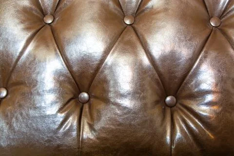 Surface of brown leather sofa. Leather with rivets. Stock Photos