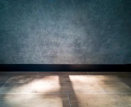 The surface of the cement wall is bare, blue-gray. Black baseboard 스톡 사진