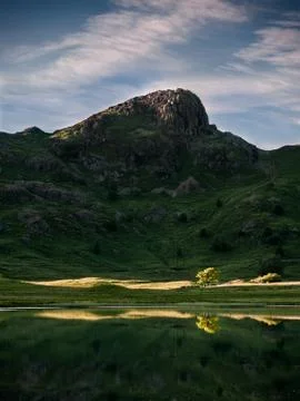 Surface of a clean pond with a reflection of a mountain massif Stock Photos